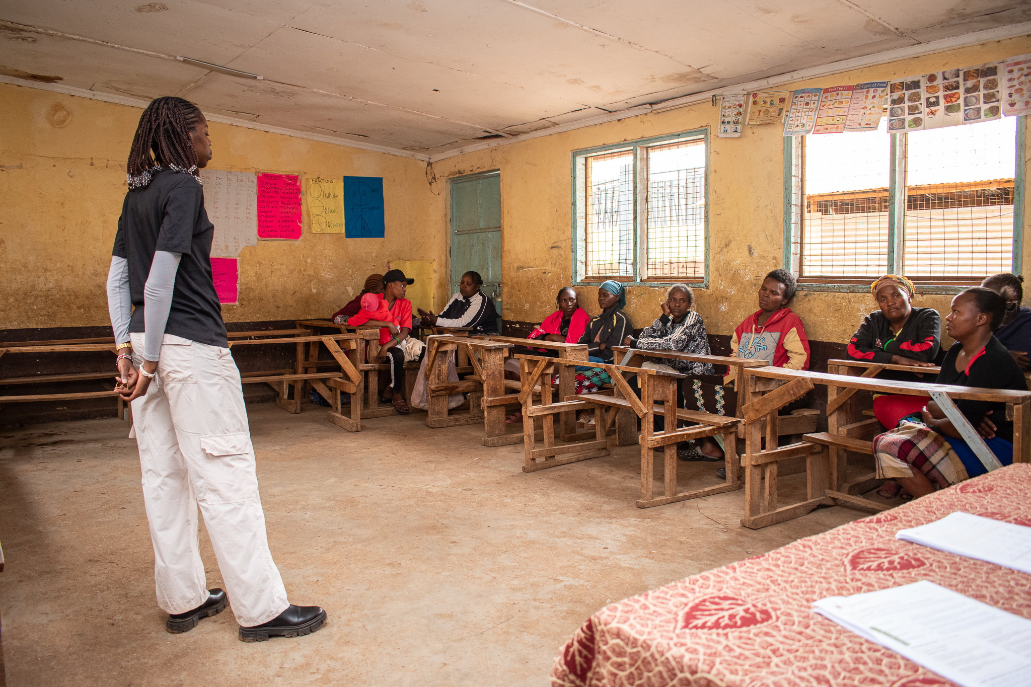 Caregivers seated in a circle in a classroom during the psychosocial first aid session