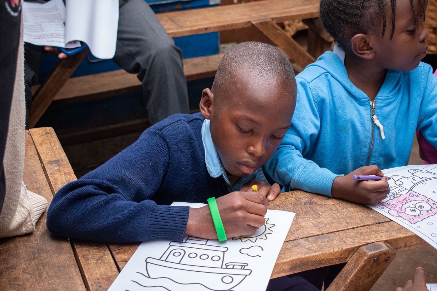 A boy concentrating on a colouring sheet
