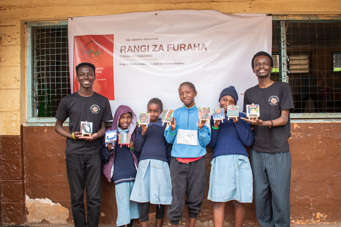 Group photograph beneath the Rangi za Furaha banner