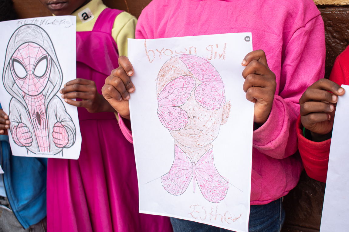 A child holding up a completed colouring sheet