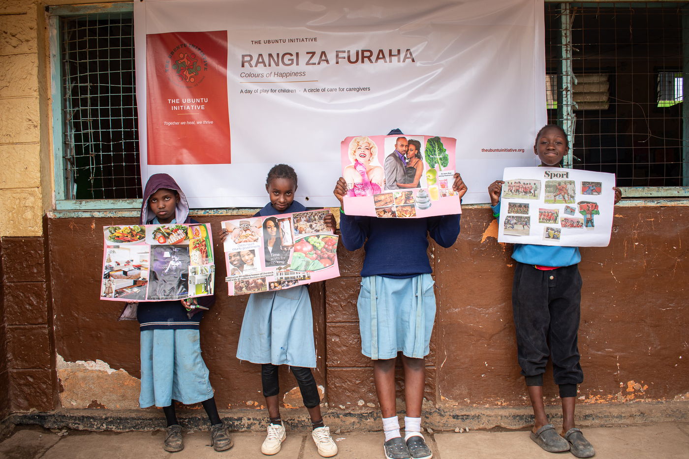 Children holding up collage and zine work beneath the event banner